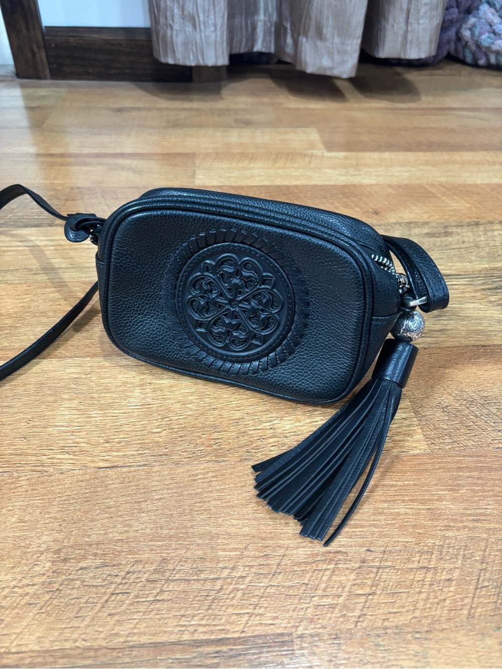 Brighton Black Leather Crossbody Bag with Tassel, heart, and adjustable strap.